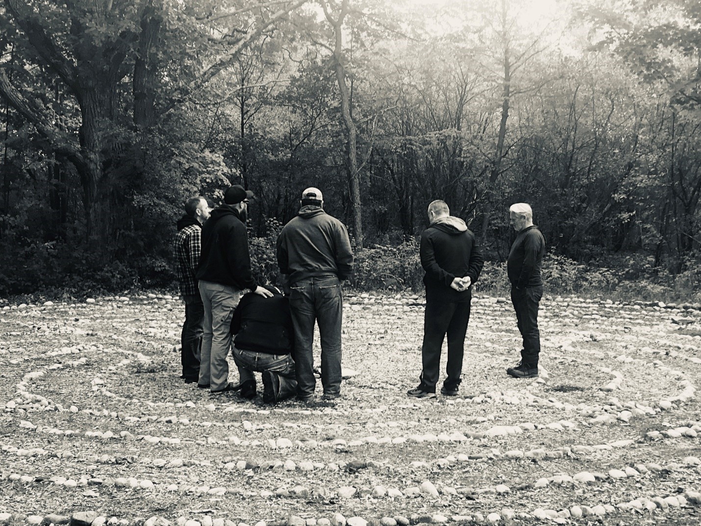 Group of participants standing together in a supportive circle representing peer support and shared healing.