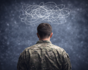 Back view of a uniformed individual with abstract swirling lines above their head representing anxiety, stress, and mental health challenges in first responders and military personnel.