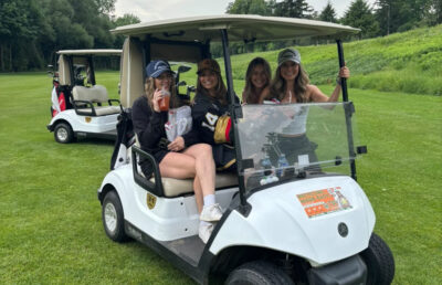 Volunteers on a golf cart before the first annual Brotherhood Project Golf Tournament supporting Project Trauma Support.