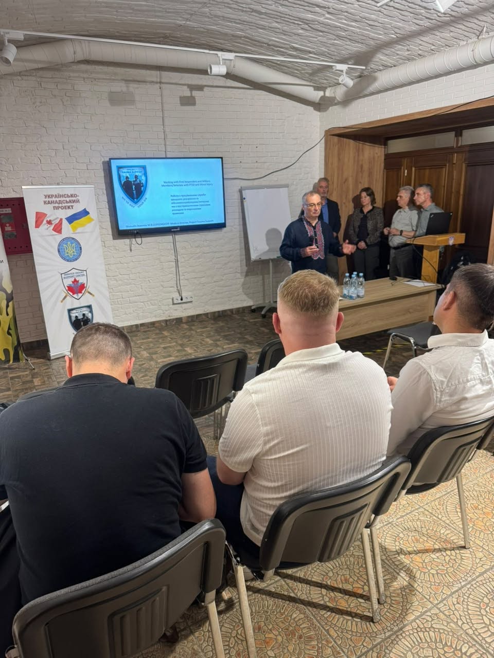 Project Trauma Support Training Session Group attending a Project Trauma Support training session in Lviv with Ukrainian-Canadian project banner.