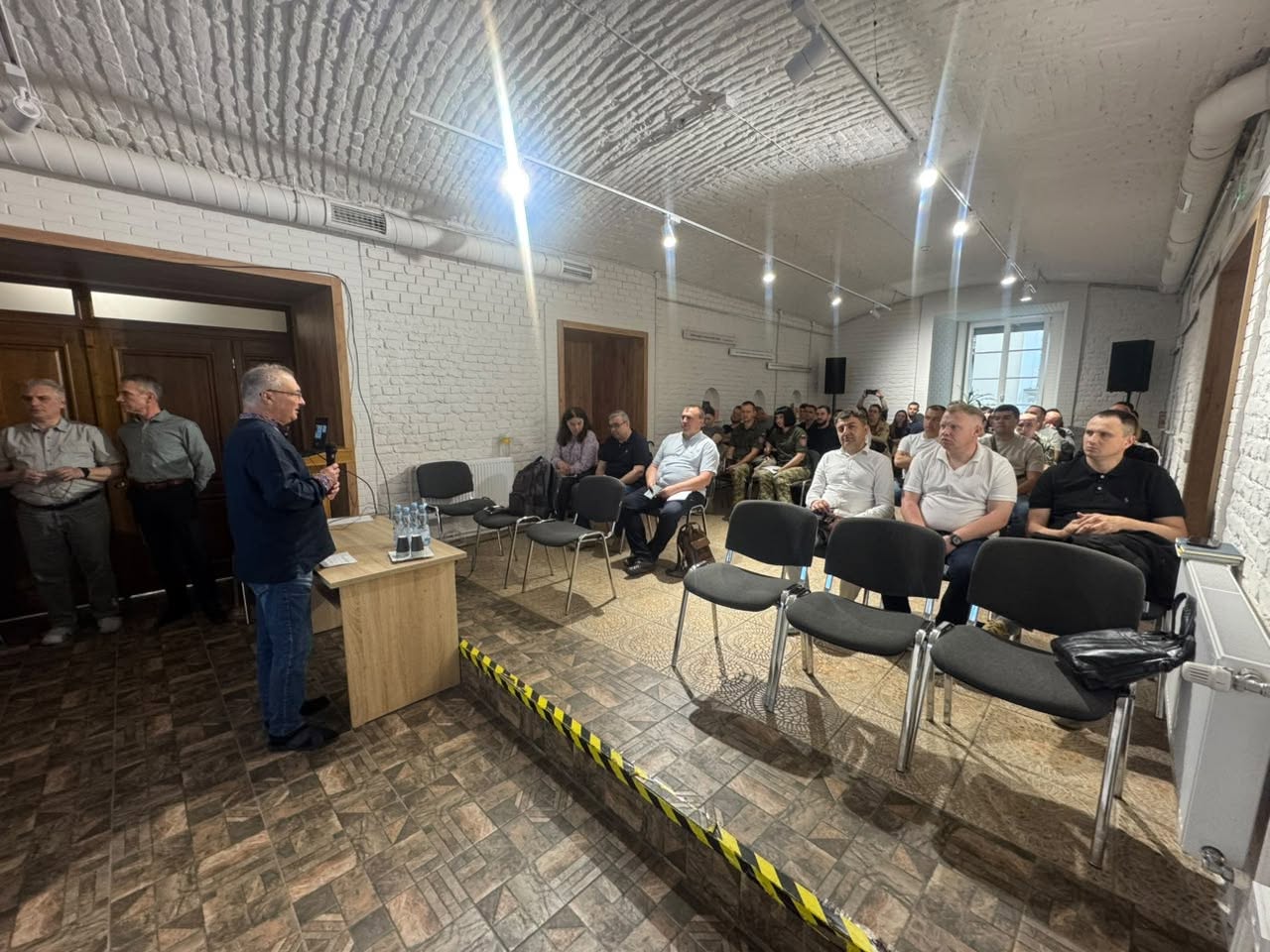 Project Trauma Support Presenter in Lviv Presenter standing at a podium during a Project Trauma Support workshop in Lviv, Ukraine.